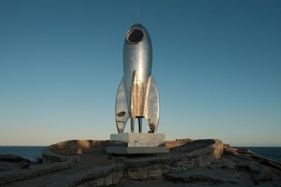 A statue of a rocket sitting on top of a rock